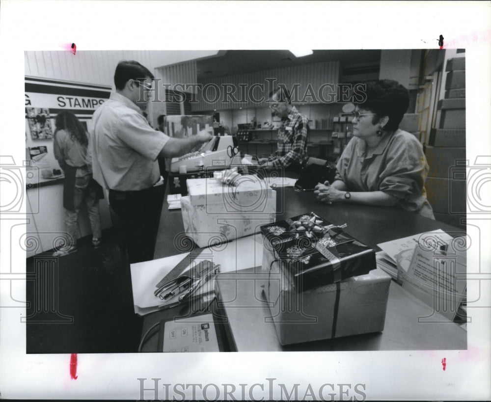 1990 Jorge Cantu Helps Marjon Bryan Mail Her Christmas Gifts. - Historic Images