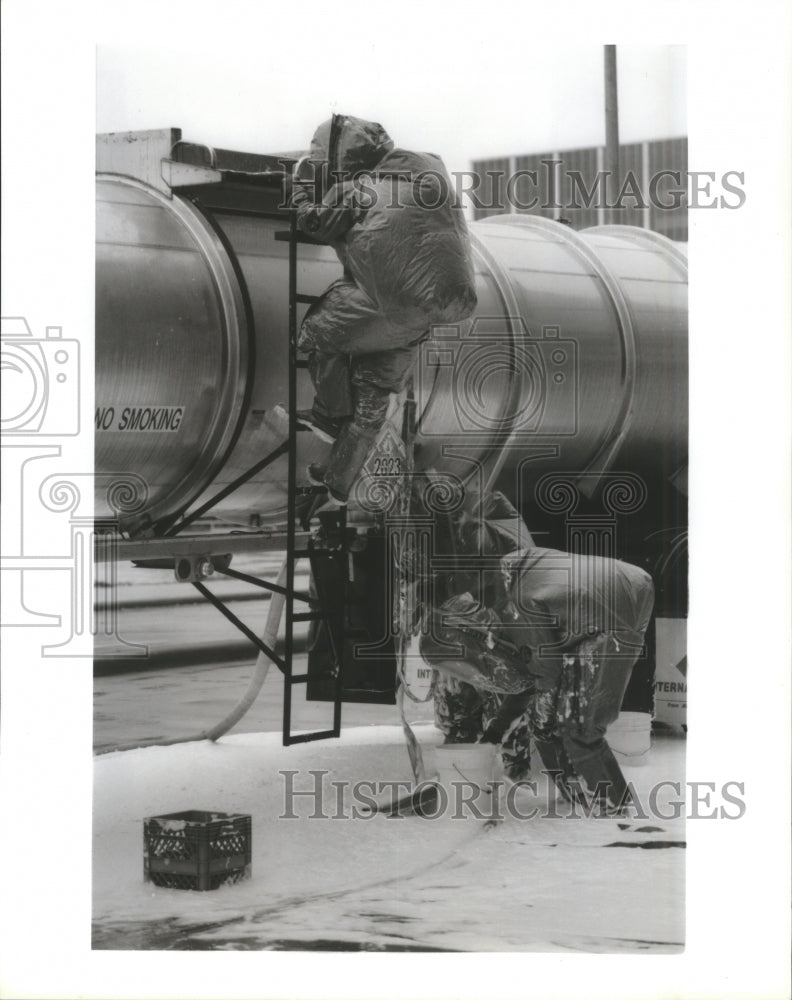 1992 Press Photo Fireman seal hole on tank truck to prevent chemical spill - Historic Images