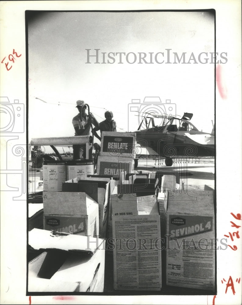 1981 Crop Dusting employees load fungicides into plane - Historic Images