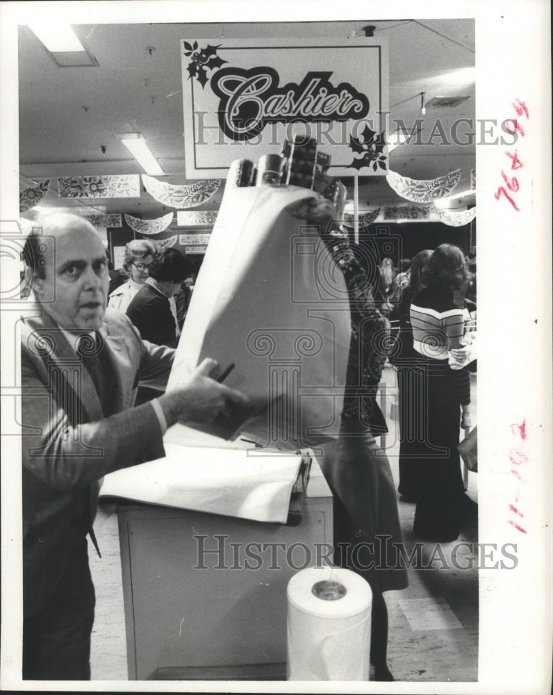 1973 Press Photo Man filling bag with Christmas wrapping paper, Houston - Historic Images