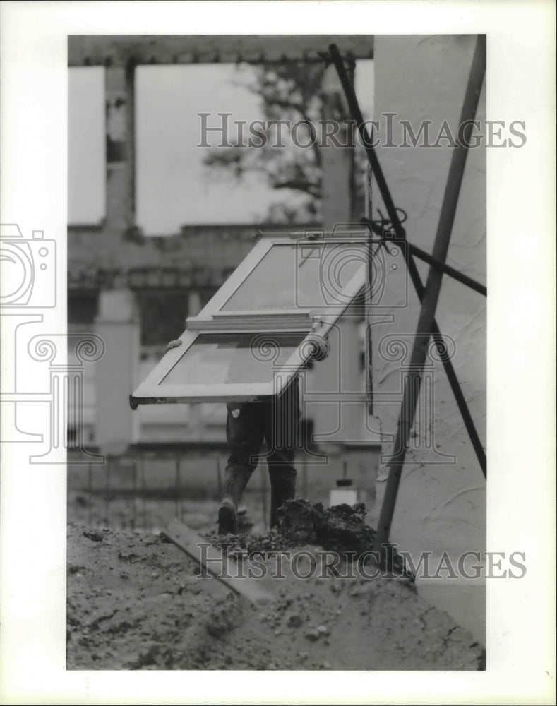 1987 Popsie Mitchell carries a door at Lee High School construction - Historic Images