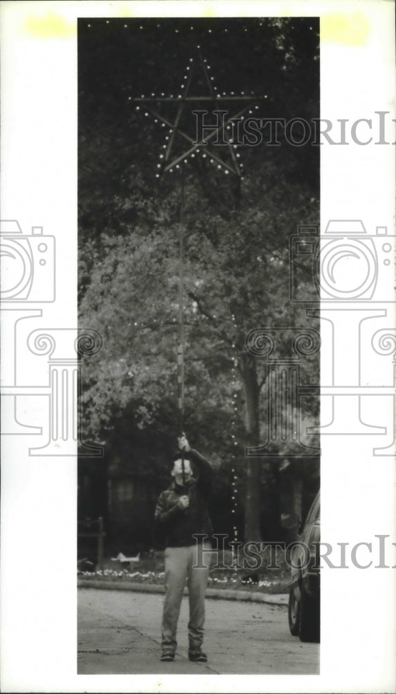 1988 John Camp uses pole for Christmas lights in Prestonwood sub. - Historic Images