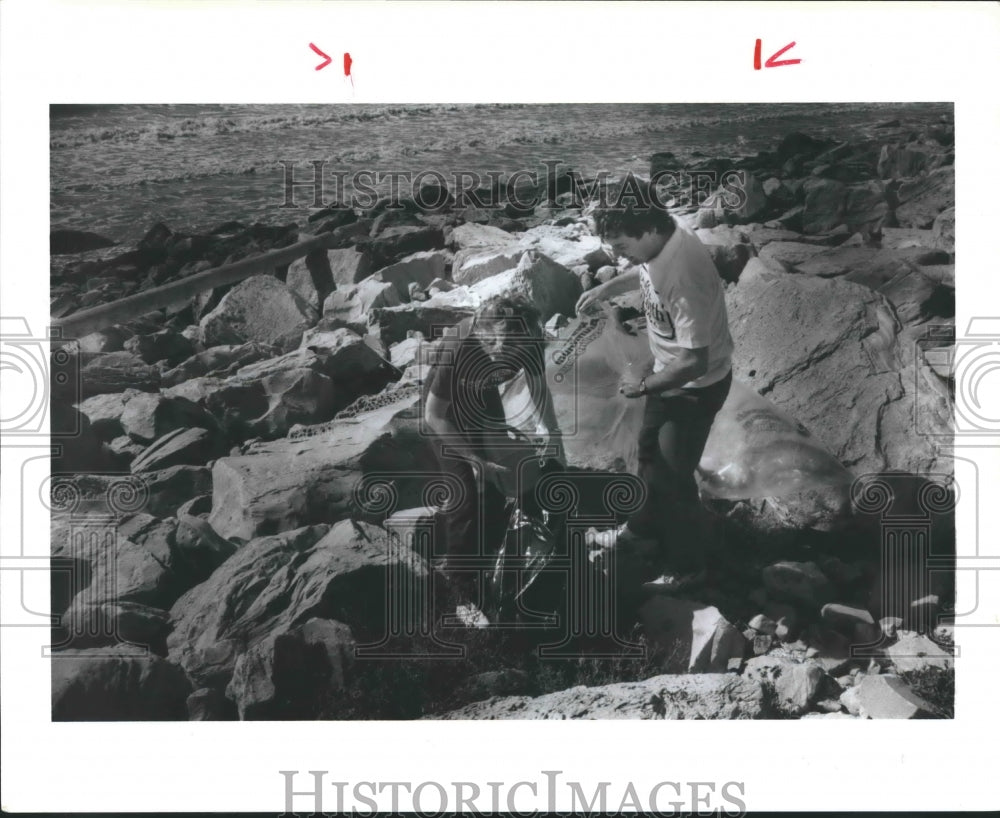 1987 Gary Mauro &amp; Geshall Pick Up Trash On Galveston Beach in Texas. - Historic Images