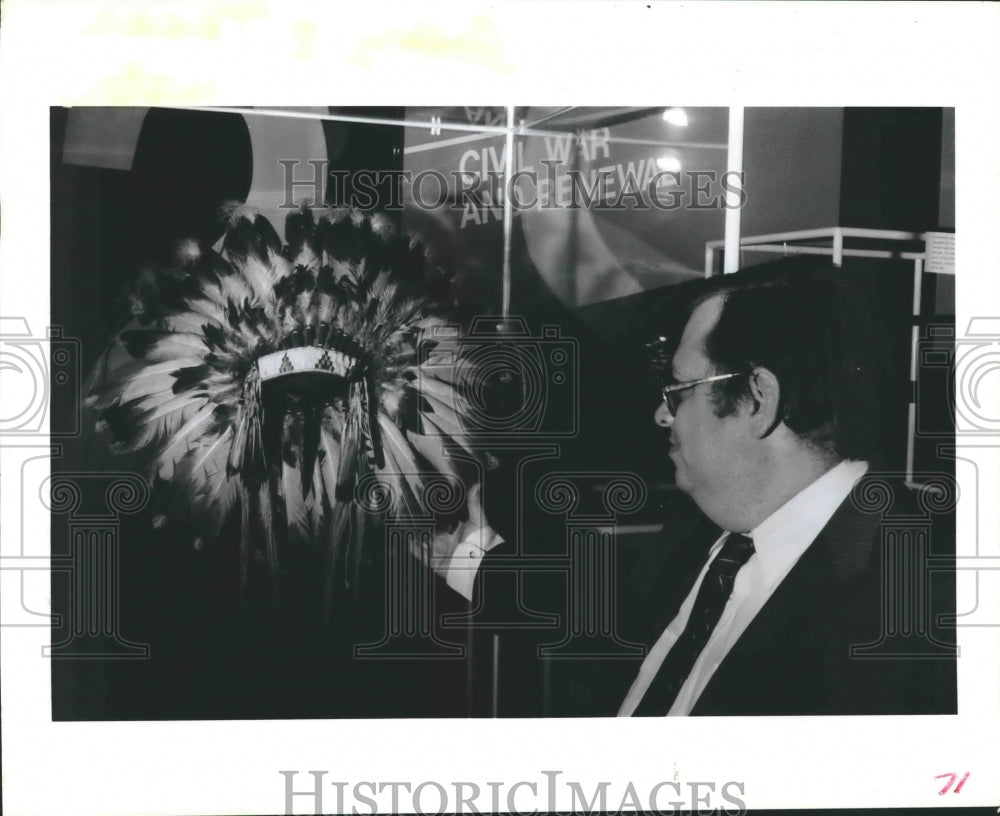 1986 Press Photo Pat Butler inspects war bonnet at Gallery of Texas History - Historic Images