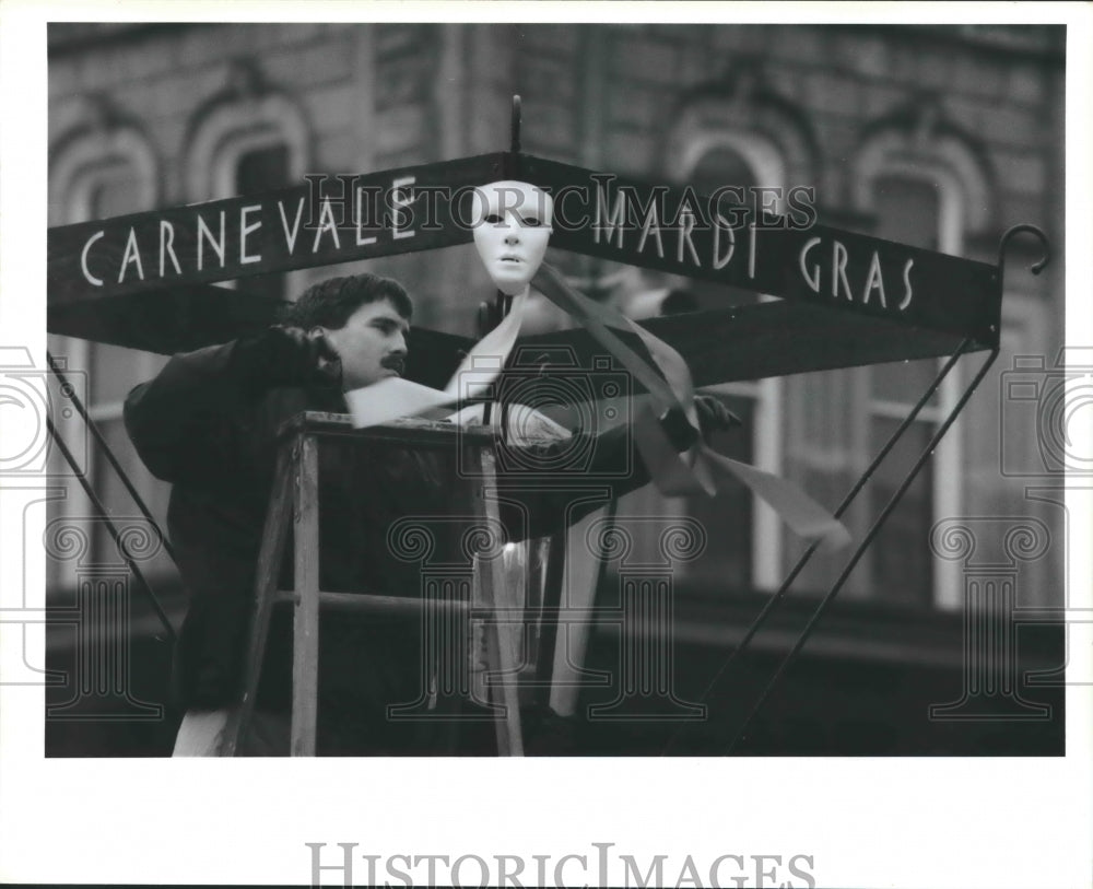 1988 Press Photo Ken Newberry installs decorations for Galveston Mardi Gras, TX - Historic Images