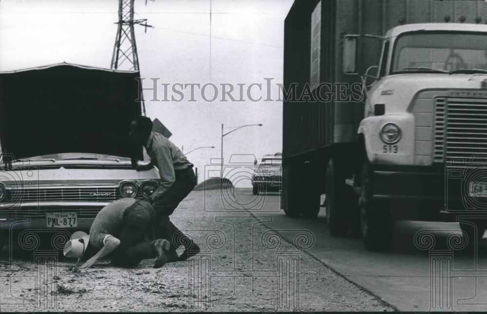 1972 Press Photo Meeks inspects under Robert Massie&#39;s car along Houston Freeway - Historic Images