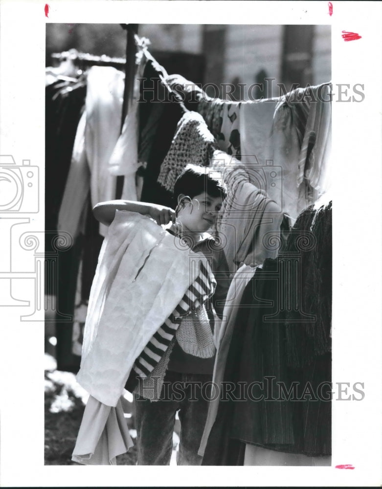 1991 Press Photo Pablo Tomayo Sells Clothing At Garage Sale in Southeast Houston - Historic Images