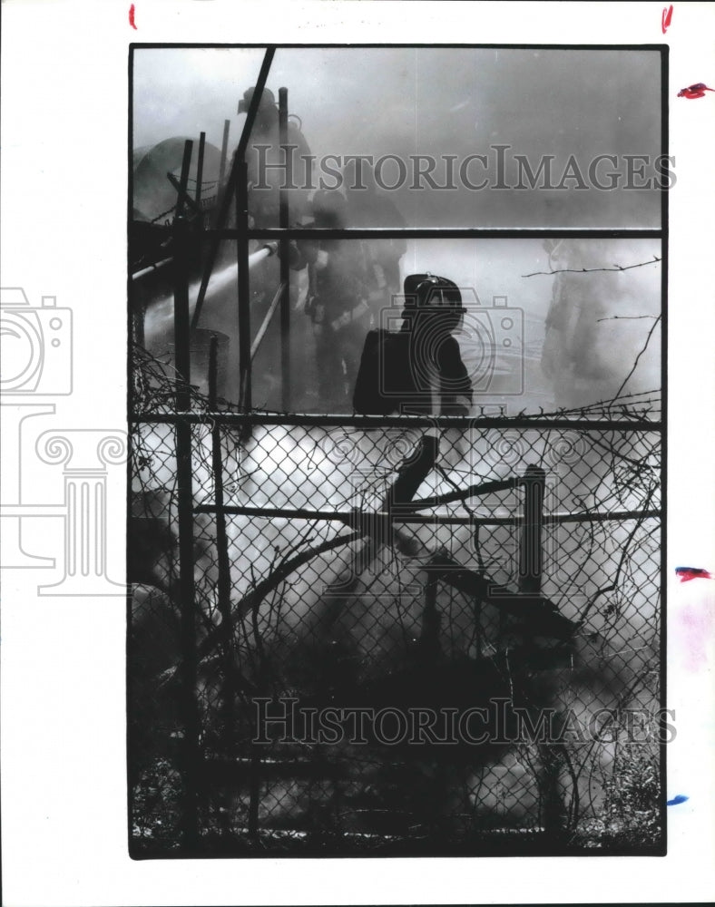 1993 Houston firefighter battles smoke and flames at a warehouse - Historic Images
