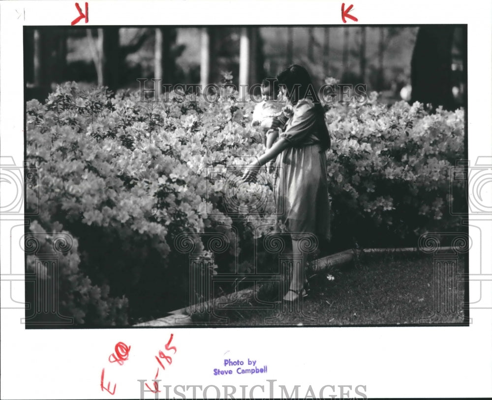 1985 Selma Assani shows daughter Sophia the bright flowers, Houston - Historic Images