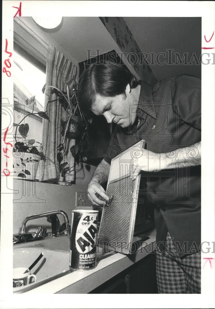 1979 Fireman Dale Everitt checking grease trap above the stove - Historic Images