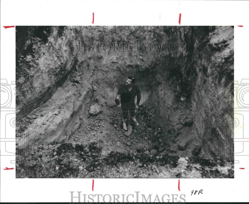 1988 Bob Harting uses metal detector in ditch dug by treasure hunter - Historic Images