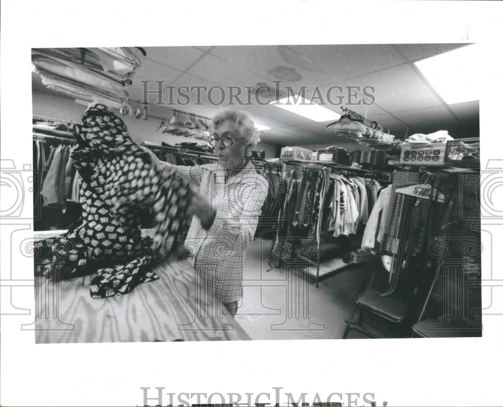 1988 Woman sorts clothes at Emergency Assistance Program, Houston-Historic Images