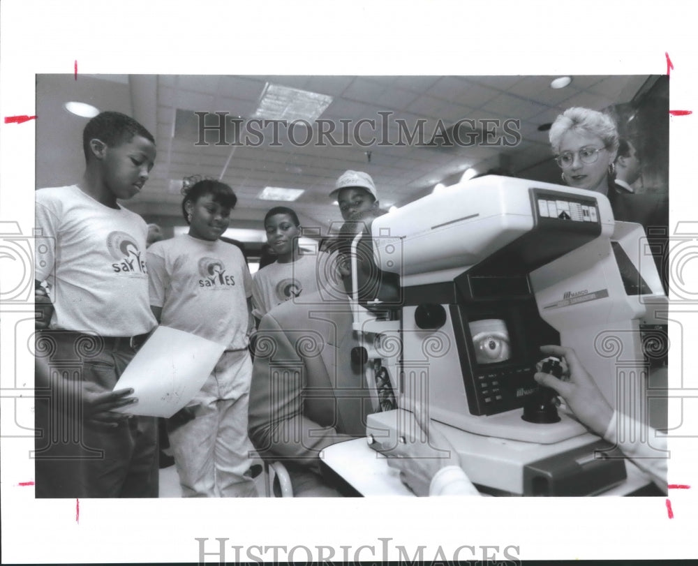 1992 Press Photo Houston Oilers' Warren Moon gets eye exam as students watch, TX - Historic Images
