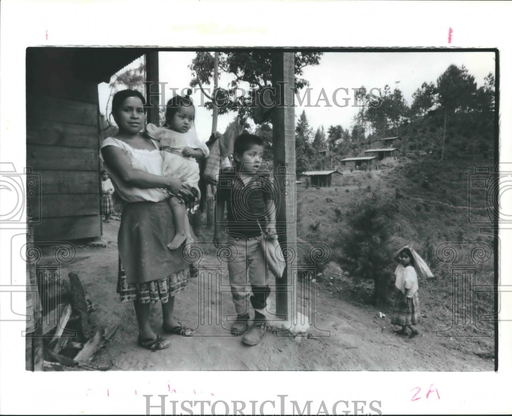 1987 Juana Si and children with model home in background, Guatemala - Historic Images