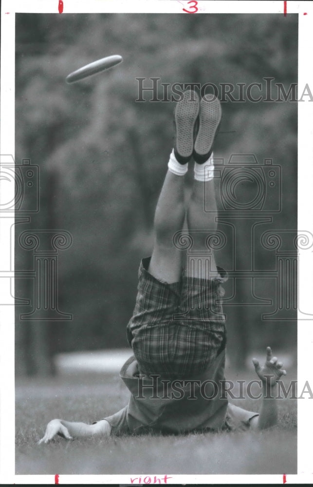 1993 Mark Hutchins trying to catch Frisbee with feet, Memorial Park - Historic Images