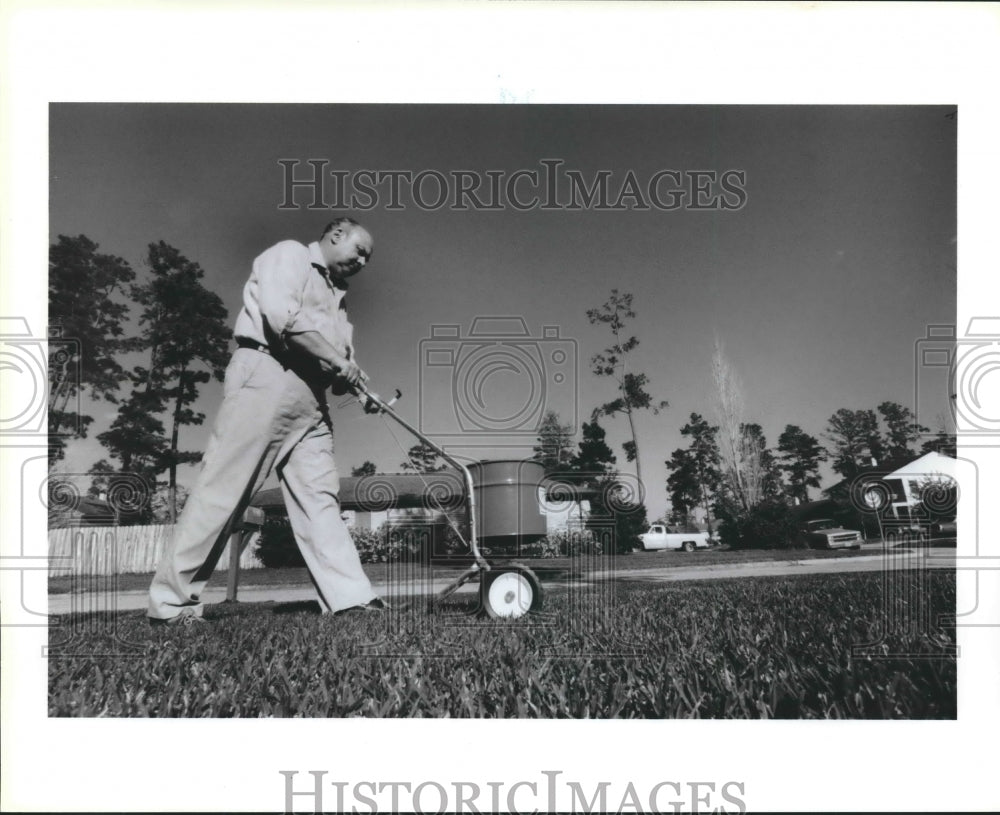 1986 Bob Main fertilizes his yard - Historic Images