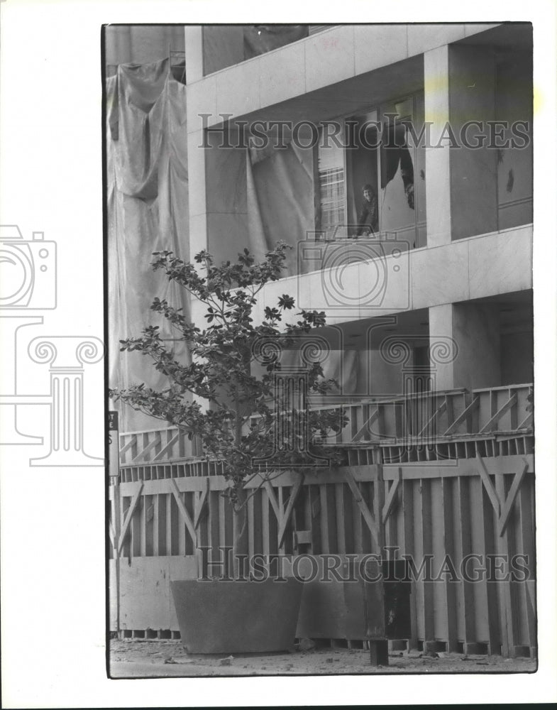 1985 Man looks out broken windows at First city Tower, Houston - Historic Images