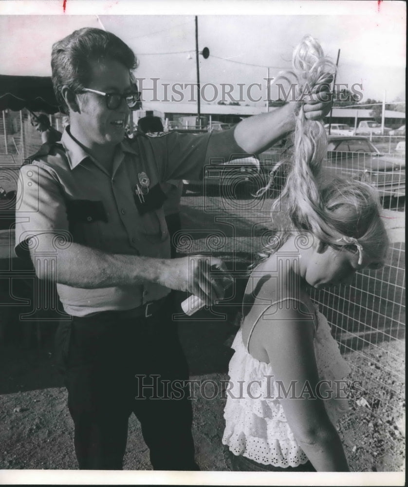 1970 Press Photo Harry Speer applies sunburn spray on neck of woman in Houston - Historic Images