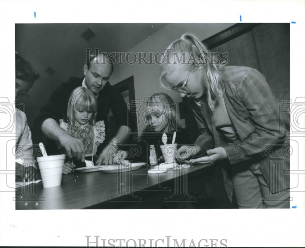 1990 Steve Seiler decorates cookies with his Girl Scout daughters - Historic Images