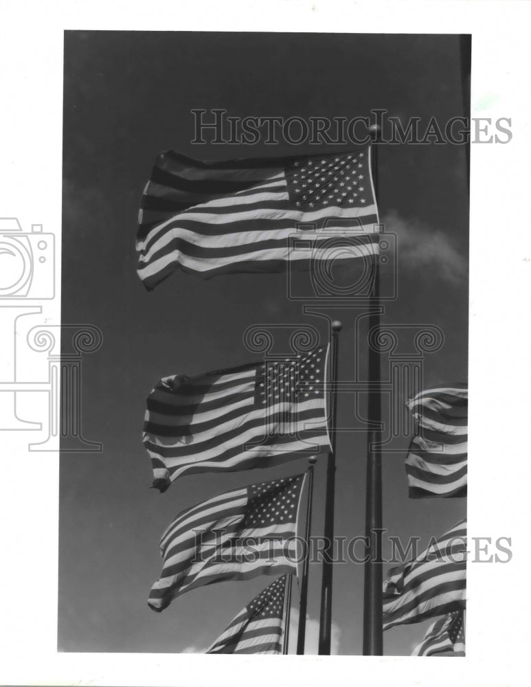 1987 Multiple American flags on flag poles wave in wind - Historic Images