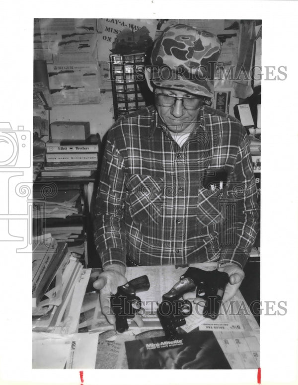 1985 Ben Pavlic, owner of Ben's Gun Ship displays handguns Historic