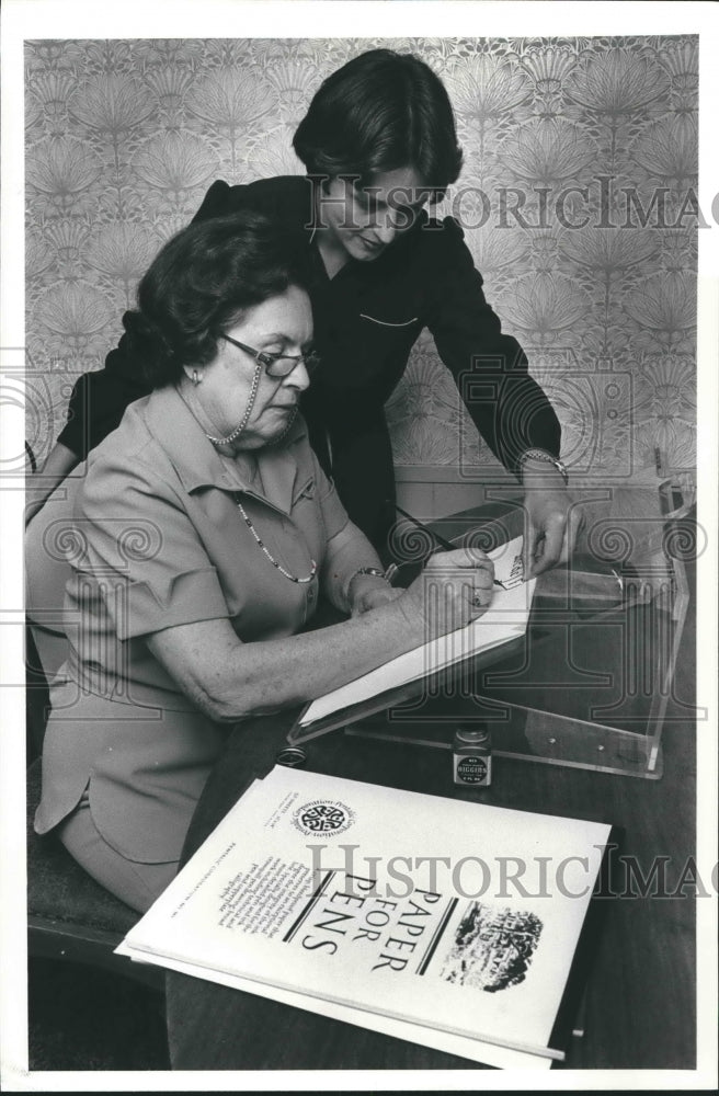 1983 Audrey Hewitt being instructed by Lynn Ayres in calligraphy - Historic Images