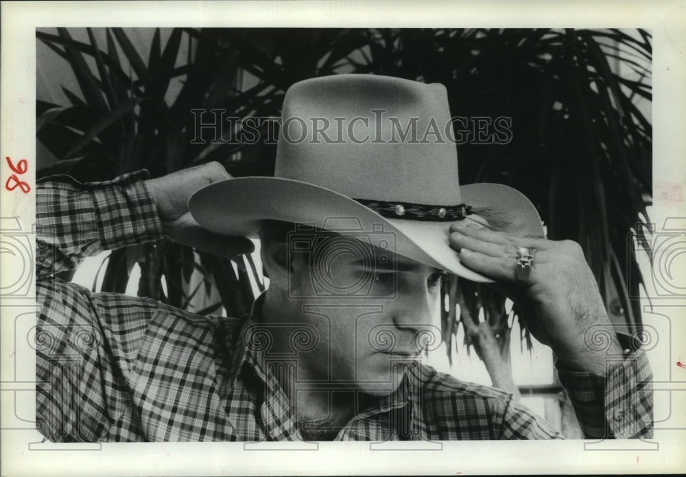 1982 Gary Cohen says handle a hat by the front & back brim - Historic Images