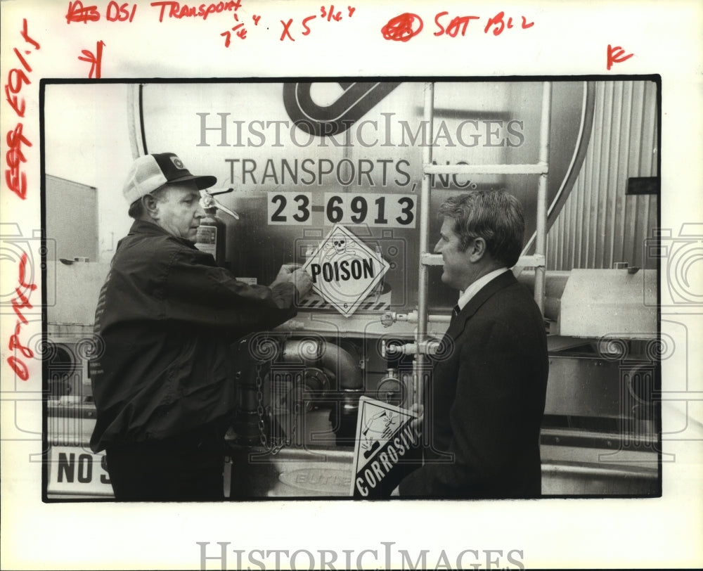 1979 Harold Scott &amp; Ted Gaylor of DSI affix hazardous sign to truck - Historic Images