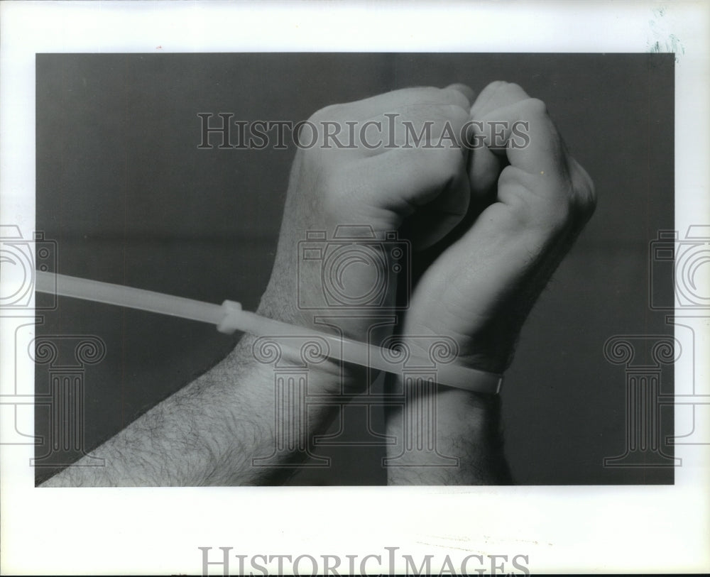 1990 Man in flex cuff handcuffs - Historic Images
