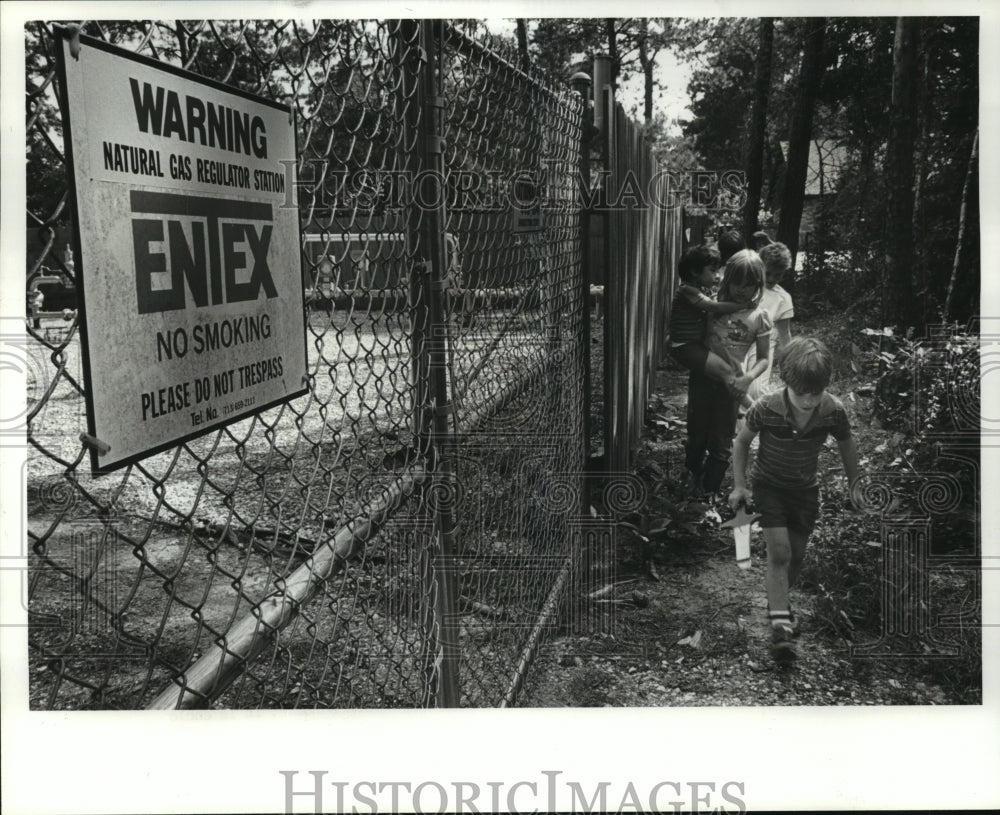 1985 Children walk past ENTEX warning sign - Historic Images