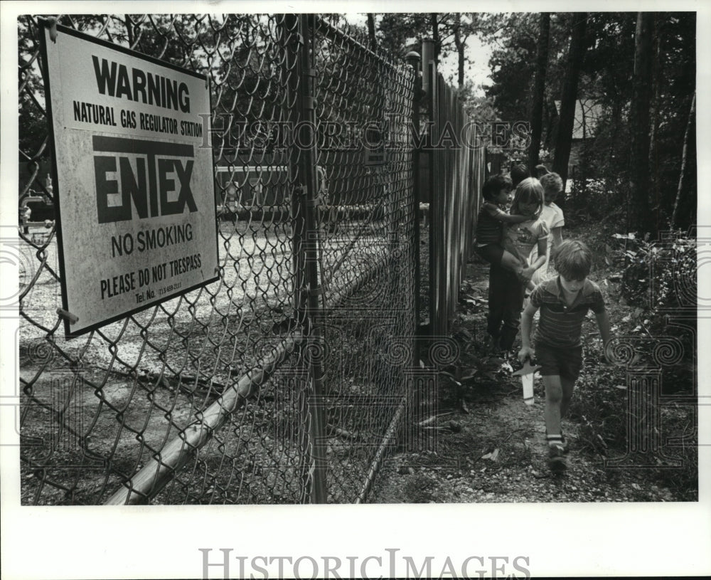 1985 Children walk past ENTEX warning sign - Historic Images