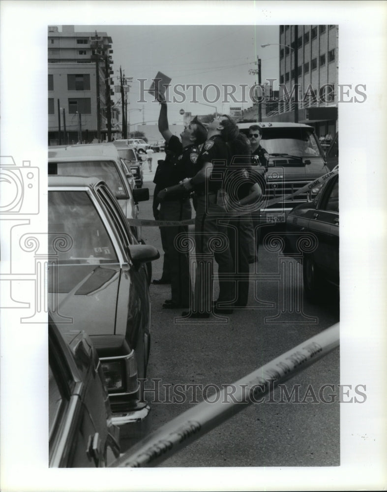 1990 Harris Co police officers look up at body and scene in Houston - Historic Images
