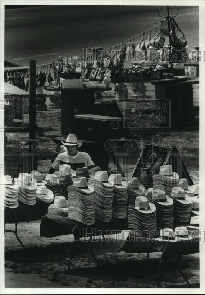 1982 Tom Banks sells hats at Texas roadside stand - Historic Images