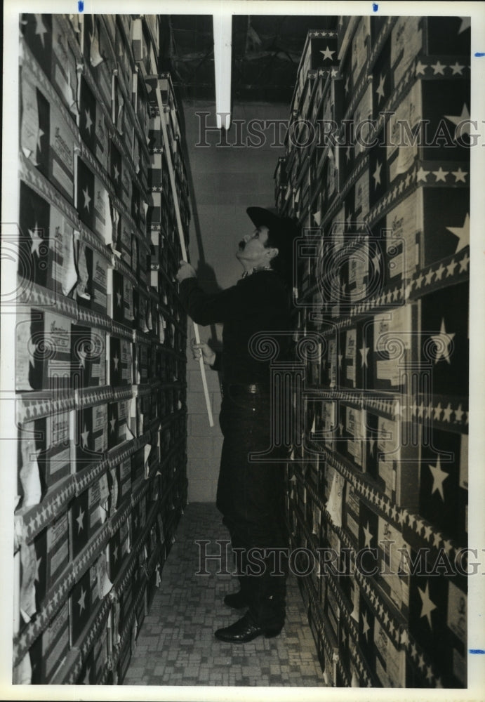 1988 Tony Matthews of The Hat Store in Houston, straightens boxes - Historic Images