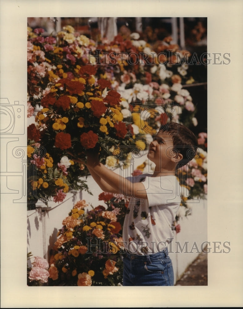 1993 Justin Dunn picks flowers for his mother in Houston - Historic Images