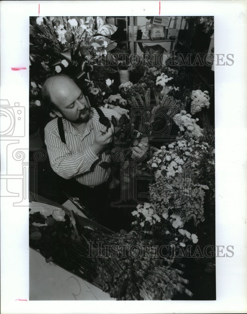 1992 Houston flower shop owner Fred Blanton examines flowers - Historic Images