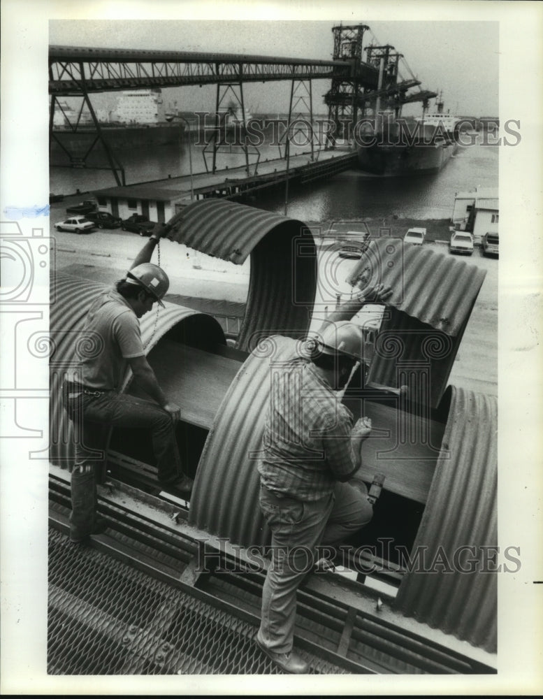 1985 Union Equity workers check grain inside conveyor in Houston - Historic Images