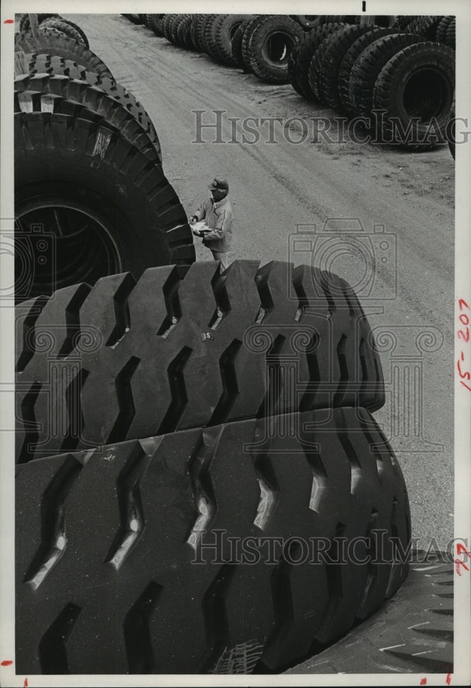 1983 Worker examines hug earthmover tires at Goodyear San Angelo, TX - Historic Images