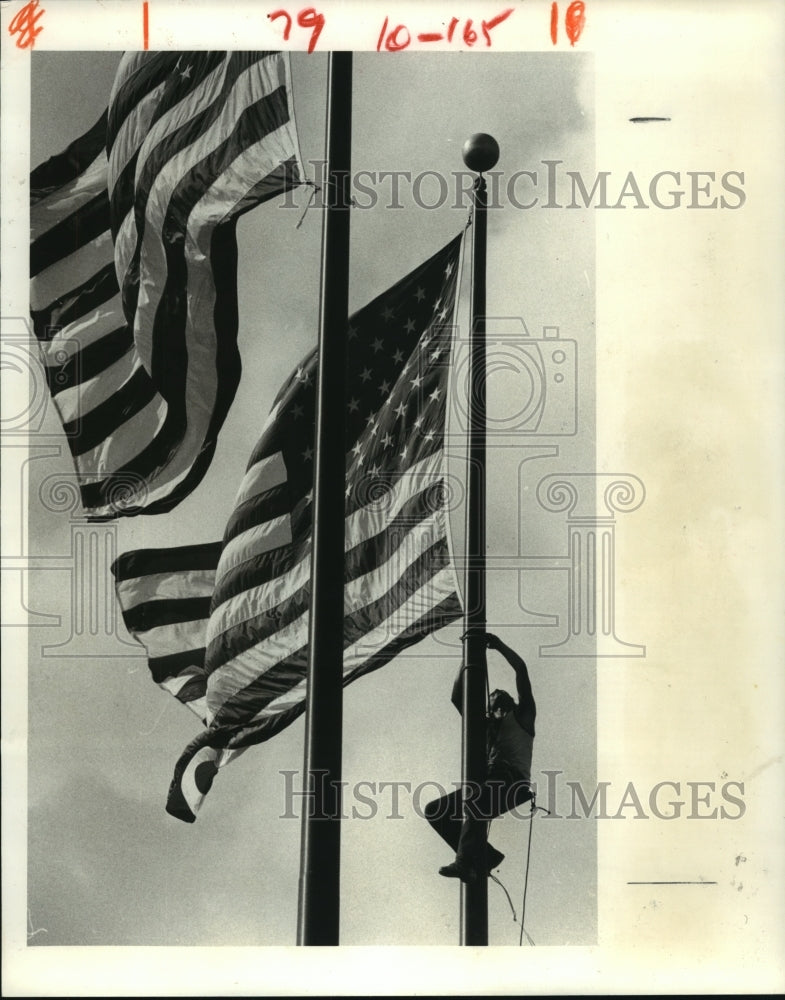 1980 Jim Maloney climbs pole to hang US flag at The Summit, Houston - Historic Images