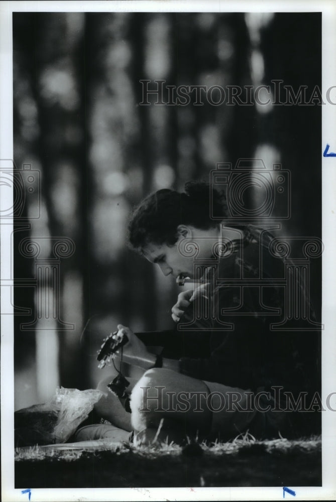 1990 Matt Rippy plays guitar in Memorial Park, Houston, Texas - Historic Images