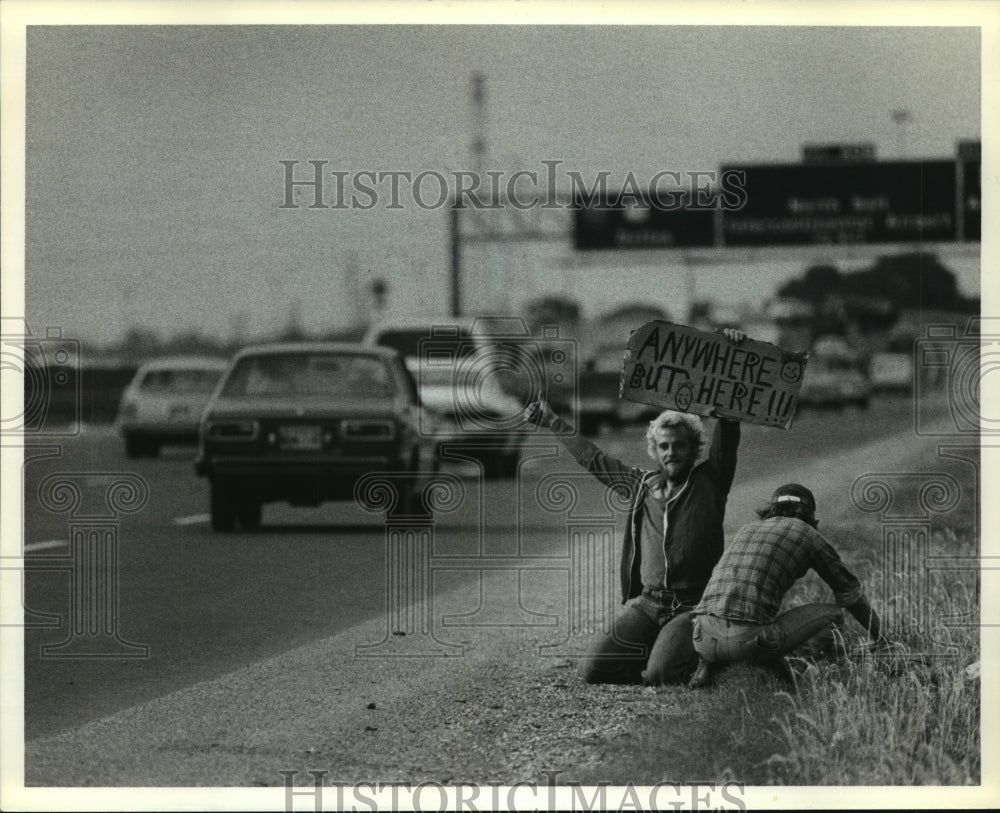 1981 Two men hitchhike along interstate - Historic Images