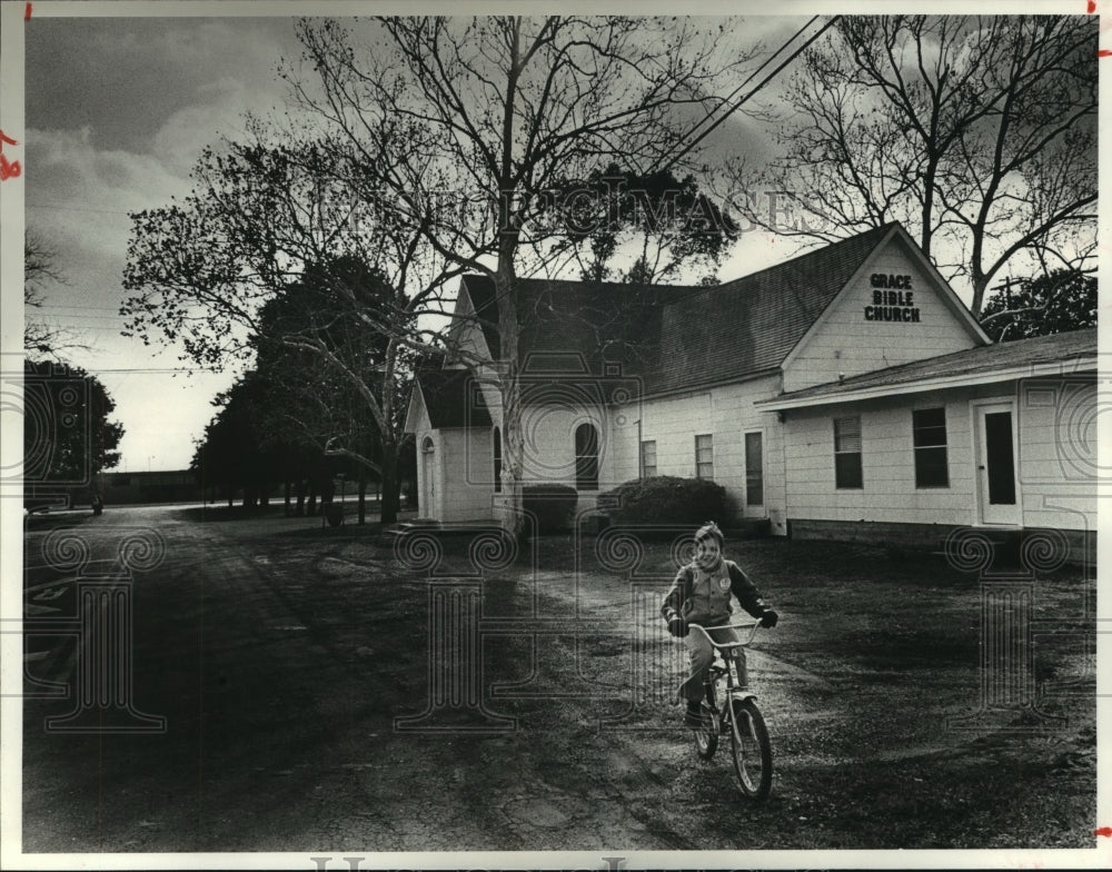 1981 Matthew Strain rides bike by home in Hitchcock, Texas - Historic Images