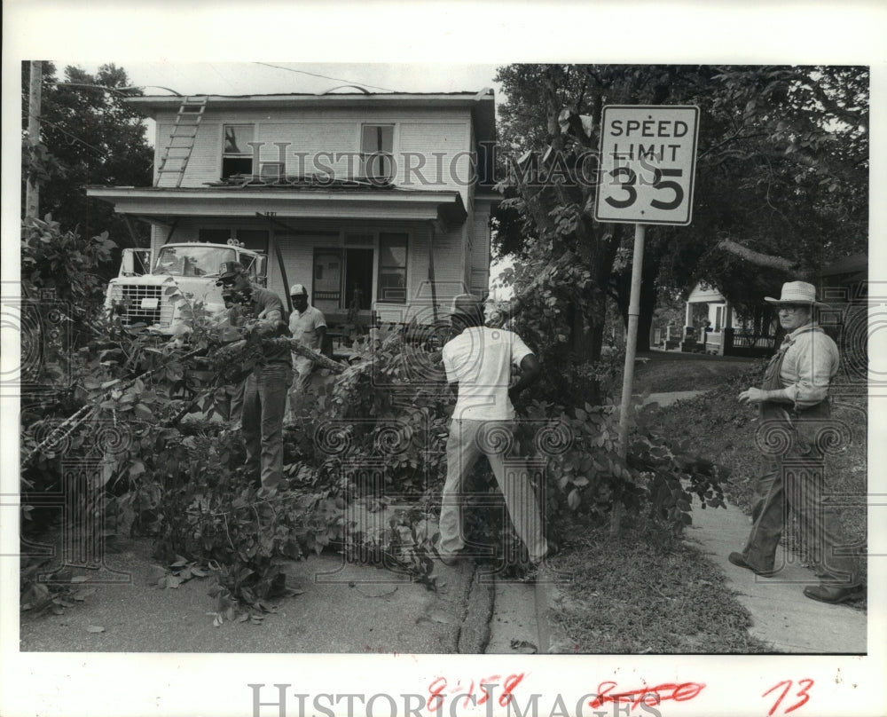 1982 Workmen cut limbs to make room for house being moved in Brenham - Historic Images