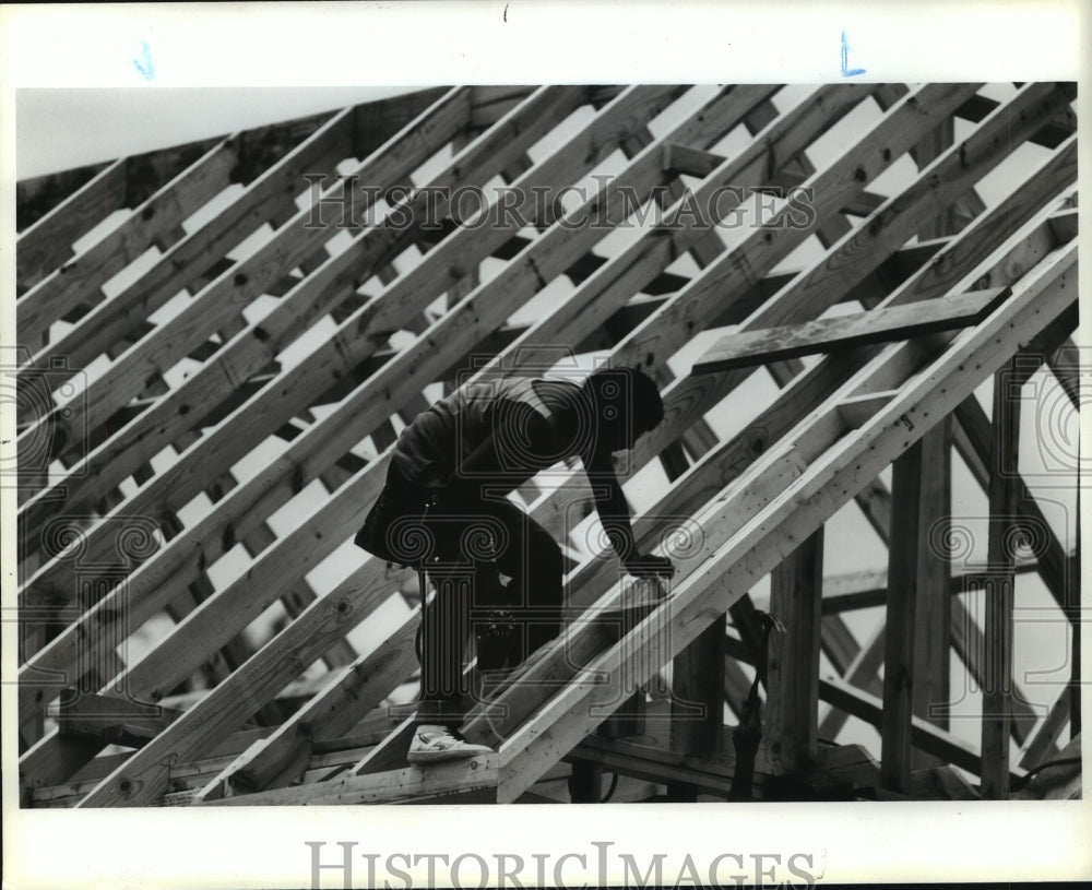 1987 Perry Homes worker frames new home roof in Houston community - Historic Images