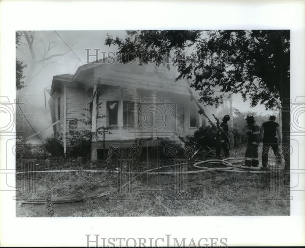 1998 Fireman spray water on fire at 307 Bryan, Houston, Texas - Historic Images