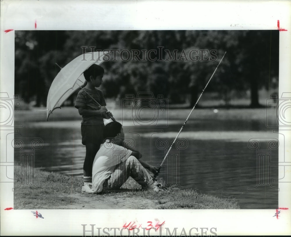 1991 Children fish at Hermann Park in Houston, Texas - Historic Images