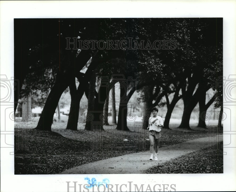 1993 Sande Ferguson jogs on path in Hermann Park in Houston - Historic Images