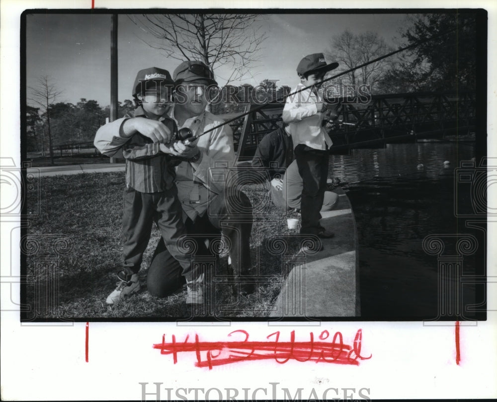 1993 Ron Frazier helps children fish at Hermann Park, Houston, TX - Historic Images