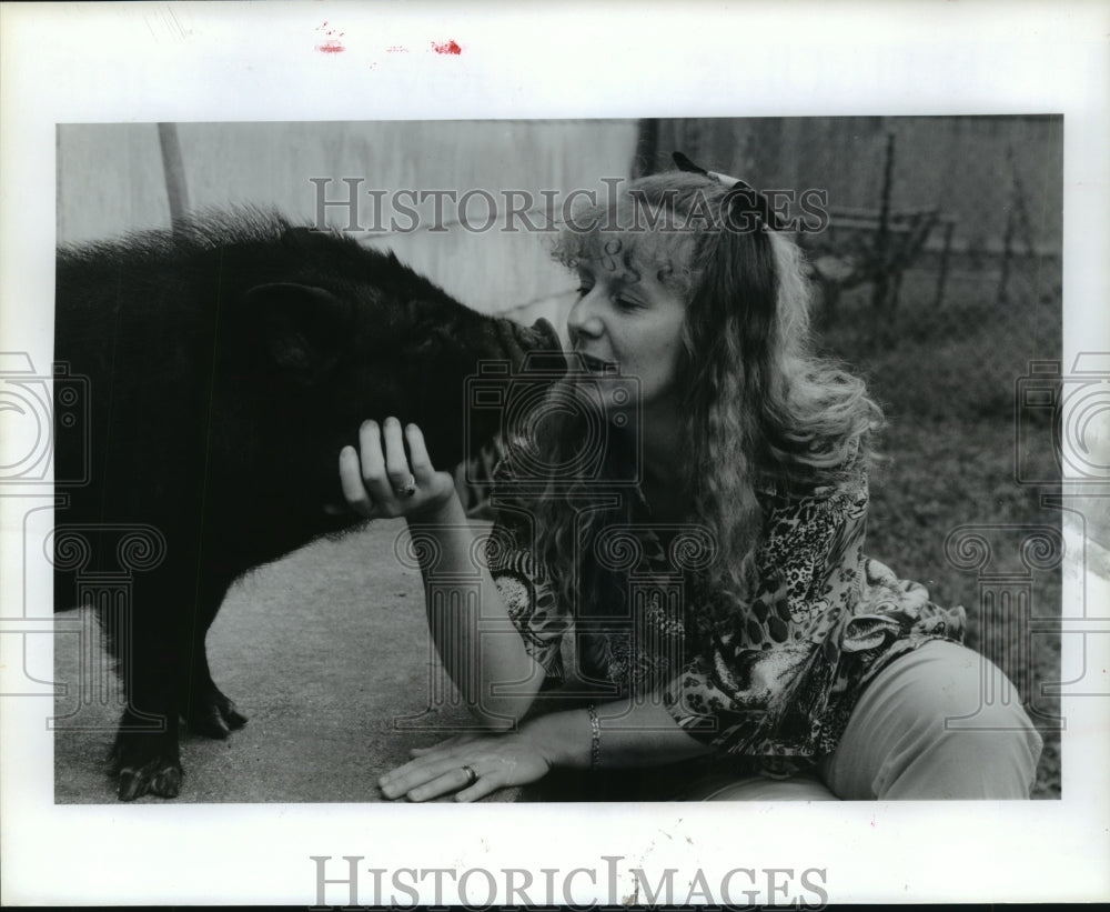1992 Lydia Nelson pets her potbellied pig, Wilbur in La Marque home - Historic Images