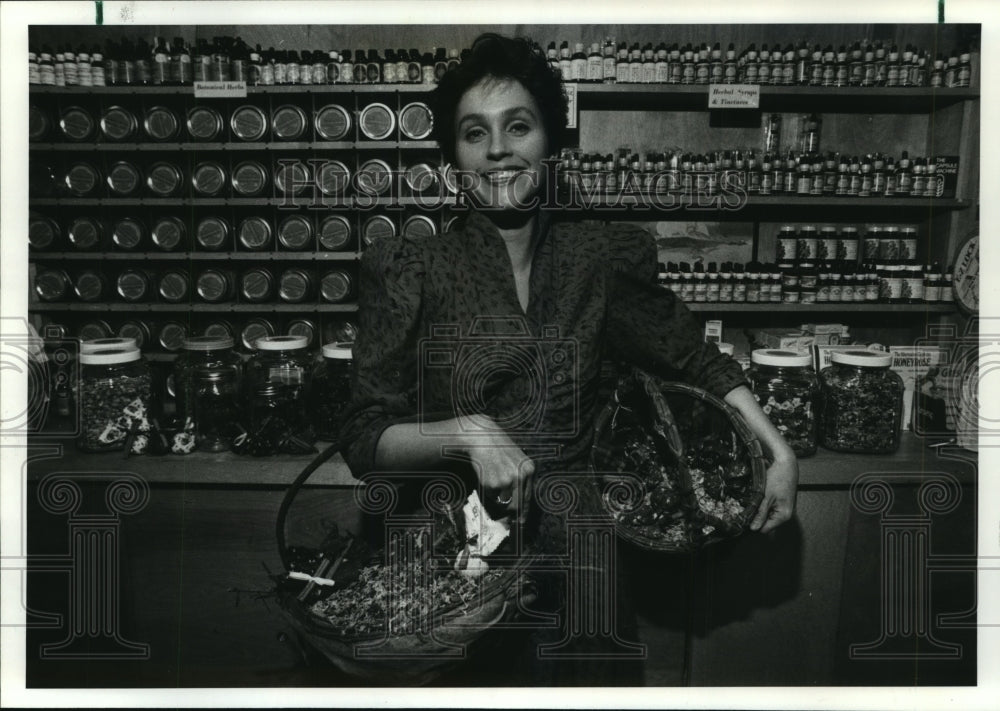 1986 Whole Foods Herbalist Amy Wall holds potpourri baskets - Historic Images